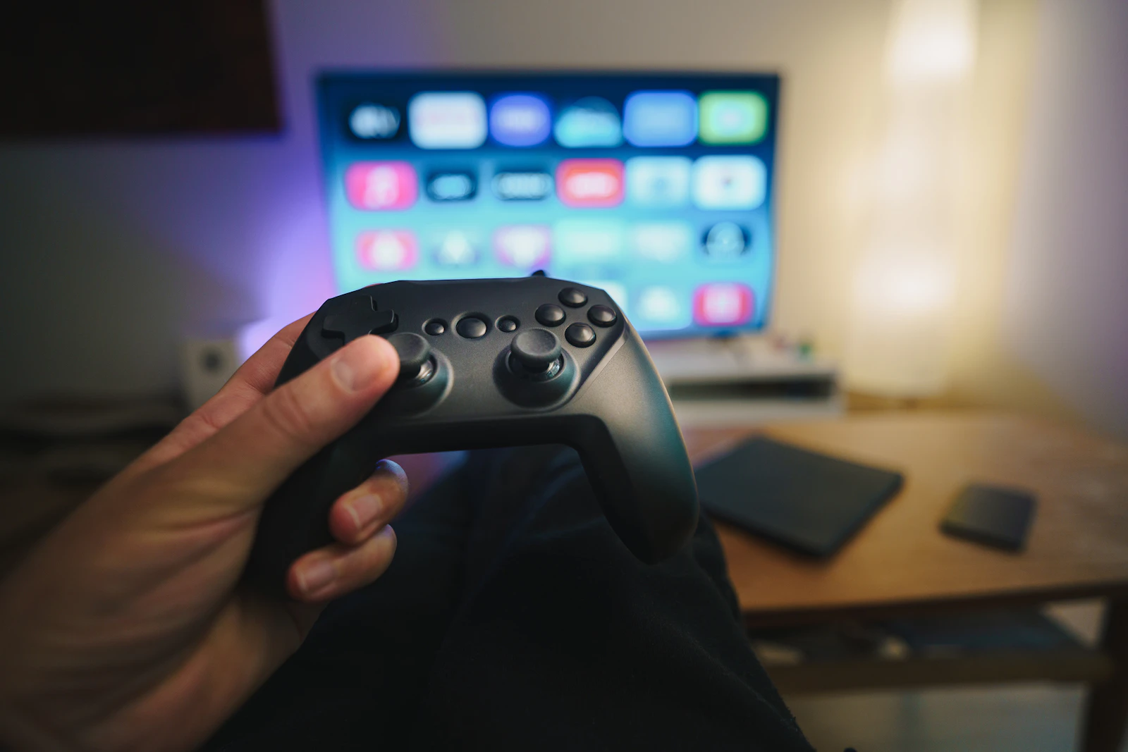 A player holding a controller in front of a gaming display